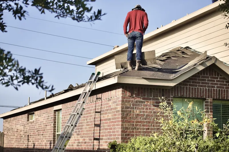 Professional roofer working on a residential roof in Carlton Village